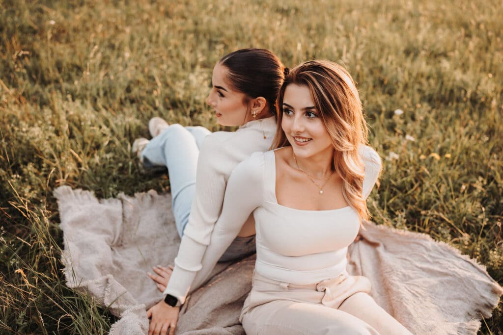 Schwestern sitzen gemeinsam bei Sonnenuntergang während eines Familienfotoshootings in Nagold