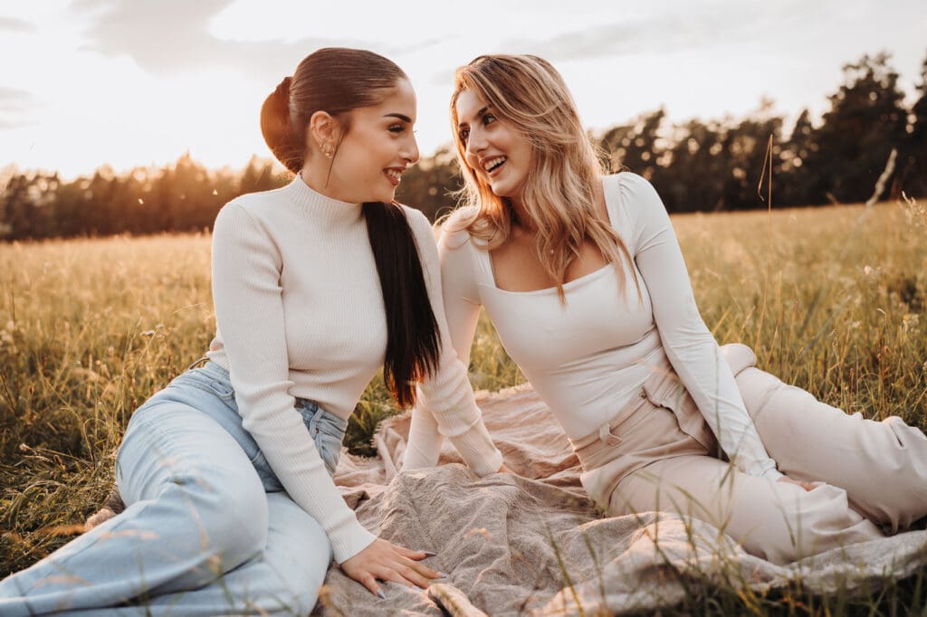 Schwestern sitzen gemeinsam bei Sonnenuntergang während eines Familienfotoshootings in Nagold