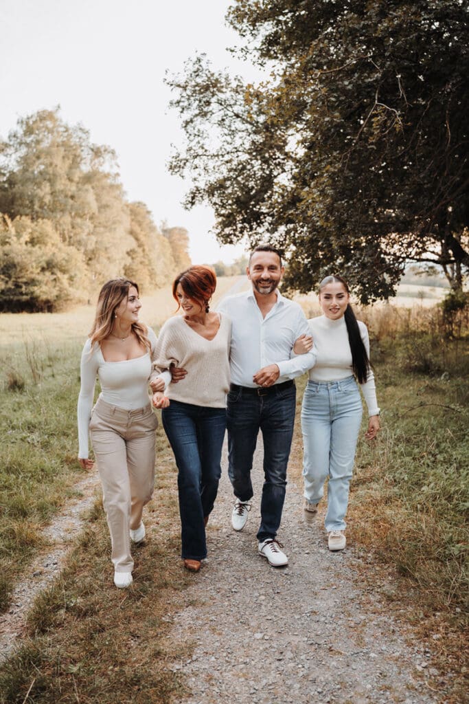Familie geht gemeinsam bei Sonnenuntergang während eines Familienfotoshootings