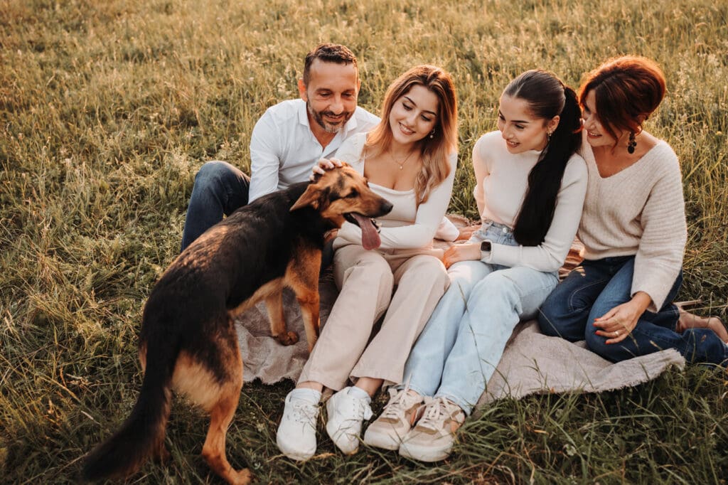 Familie sitzt gemeinsam mit ihrem Hund während eines Familienfotoshootings in Nagold