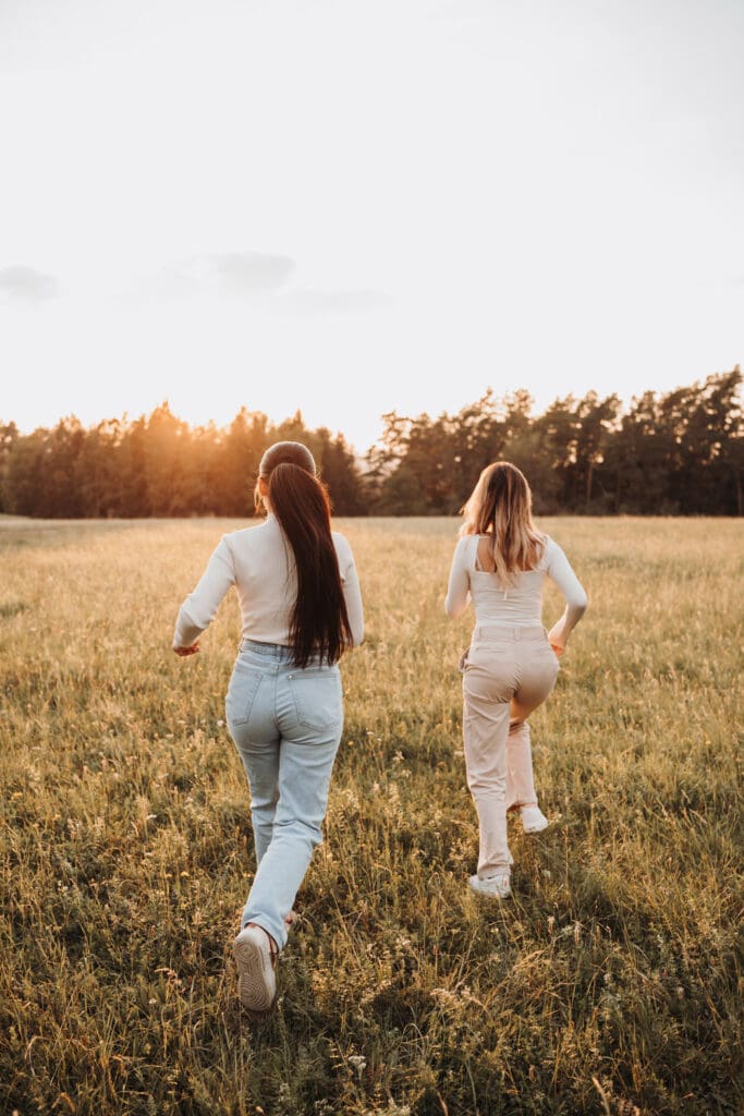 Schwestern rennen während eines Familienfotoshootings in Nagold