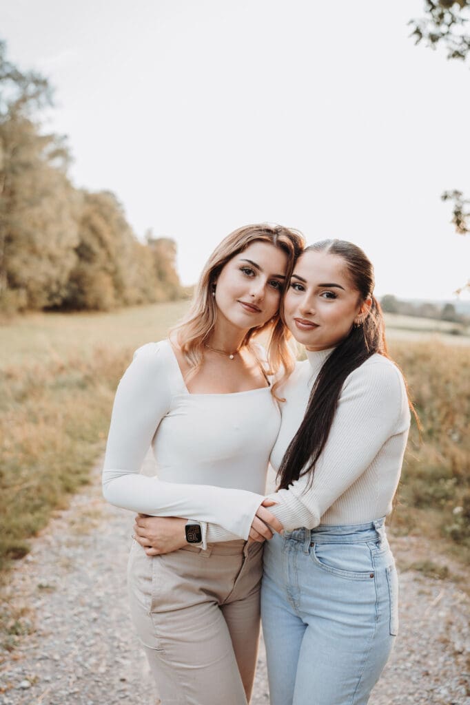 Zwei Schwestern kuscheln sich während eines Familienfotoshootings aneinander